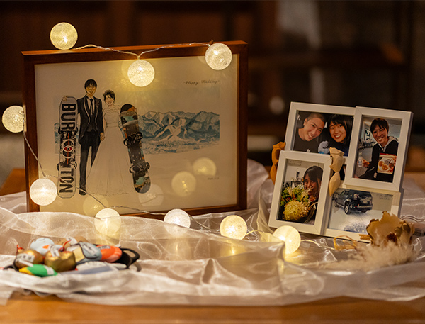 この度は、とても素敵な絵を描いて頂き、ありがとうございました。

夫婦でドキドキしながら「せーの！」で開封し、一言目が「わぁ、めっちゃ富良野だ！」でした。
(その後で「ボードの再現がすごい！」とか「似てる！」とかで大盛り上がりしていました！)

私たちが大好きだった風景が本当にそのままに描かれていて、些細な思い出までが蘇ってくるような絵です。
お伝えさせて頂いた思いを、大切に丁寧に込めて描いてくださったのだなと、感謝の気持ちでいっぱいです。

結婚式はゲストに楽しんでもらう・喜んでもらうことを第一に準備を進めているのですが、
何かひとつ、自分たちのために、結婚式の記念として形に残るものがあったらいいなと思い、似顔絵を依頼させて頂きました。
この上なく素敵な記念の品となり、式当日のウェルカムボードとして飾るのはもちろん、その後に家に飾るのが楽しみで待ち遠しいです。

夫婦の宝物にします。
感謝・感激・感動を上手く文章でお伝えできないのがもどかしいですが、本当にありがとうございました。